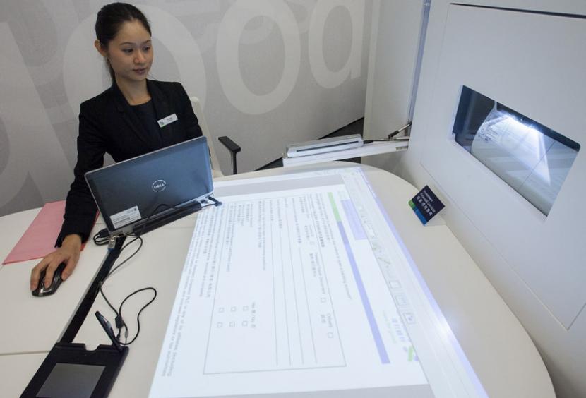  Meja interaktif dan papan tanda tangan elektronik memudahkan nasabah bank mengakses layanan tanpa kertas. 