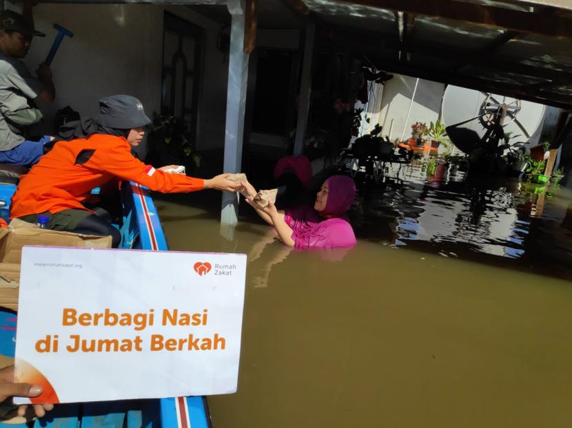 Melalui Program Berbagi Nasi di Jumat Berkah, Relawan Rumah Zakat menyisir rumah warga yang masih terendam banjir di Kelurahan Kampung Ladang menggunakan perahu.