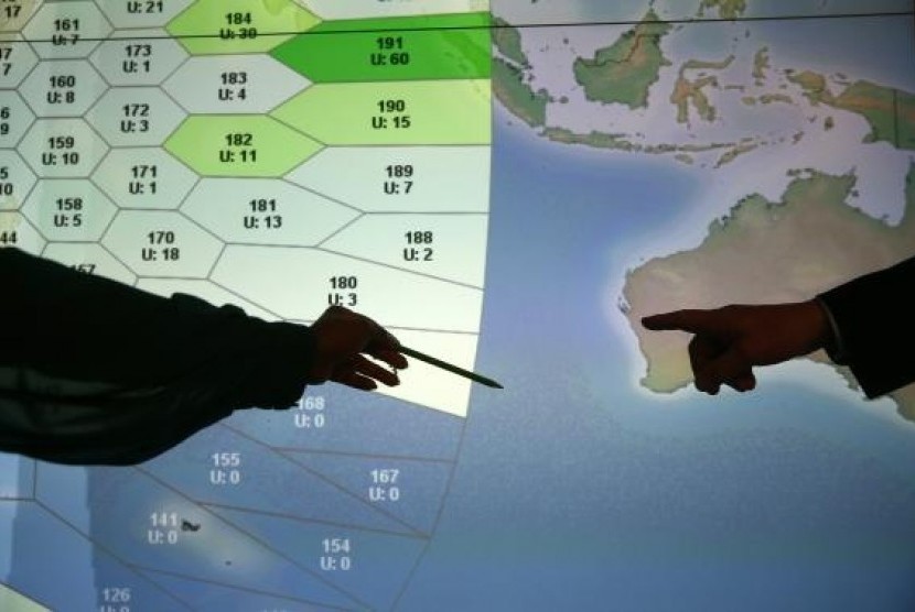 Member of staff at satellite communications company Inmarsat point to a section of the screen showing the southern Indian Ocean to the west of Australia, at their headquarters in London March 25, 2014.