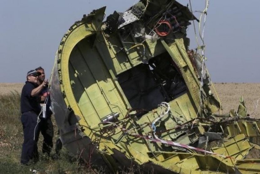 Members of a group of international experts inspect wreckage at the site where the downed Malaysia Airlines flight MH17 crashed, near the village of Hrabove (Grabovo) in Donetsk region, eastern Ukraine August 1, 2014.
