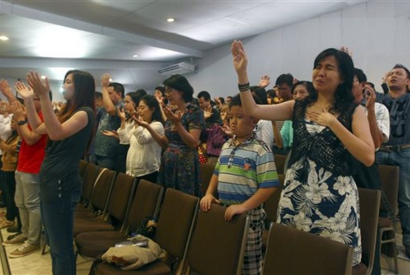 Members of Mawar Sharon church attend a prayer service for the relatives of lost loved ones aboard the AirAsia Flight 8501, in Surabaya, East Java, Indonesia Sunday, Jan. 4, 2015. About 40 members of the church were aboard the plane which crashed into the 