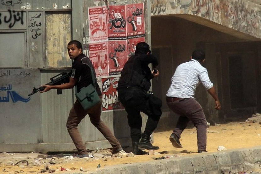 Members of the Egyptian security forces hold guns during clashes with supporters of the Muslim Brotherhood outside Al-Azhar University in Cairo, Egypt, Friday, May 23, 2014. 