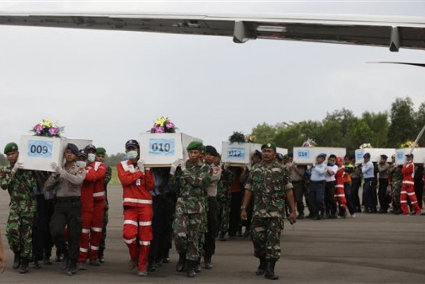Members of the National Search And Rescue Agency carry coffins containing bodies of the victims aboard AirAsia Flight 8501 to transfer to Surabaya at the airport in Pangkalan Bun, Indonesia, Friday, Jan. 2, 2015. 