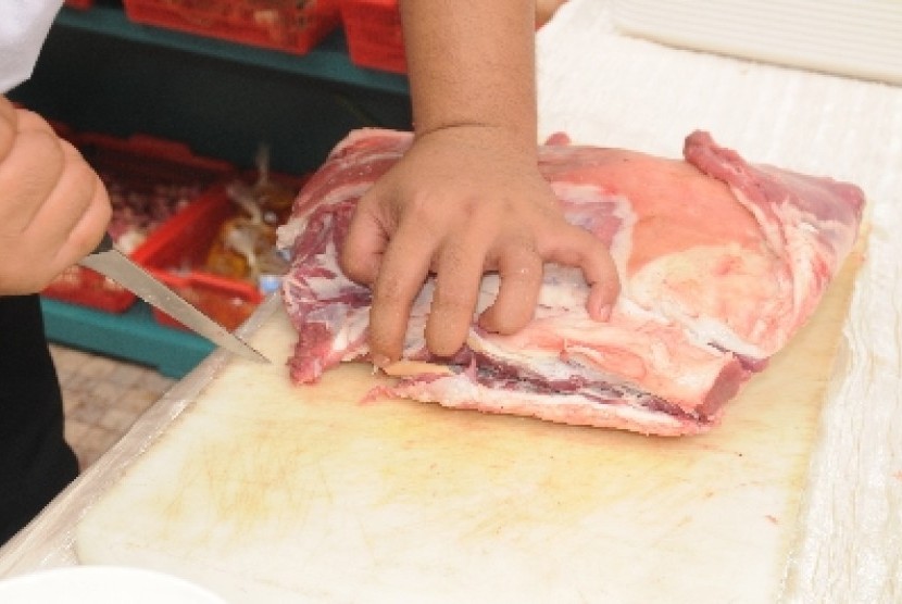 Memotong daging kambing.