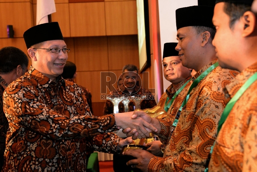 Menag Lukman Hakim Saifuddin memberikan penghargaan saat acara penganugrahan kantor urusan agama (KUA) dan keluarga sakinah teladan tingkat Nasional 2015 Di Jakarta, Selasa (18/8).
