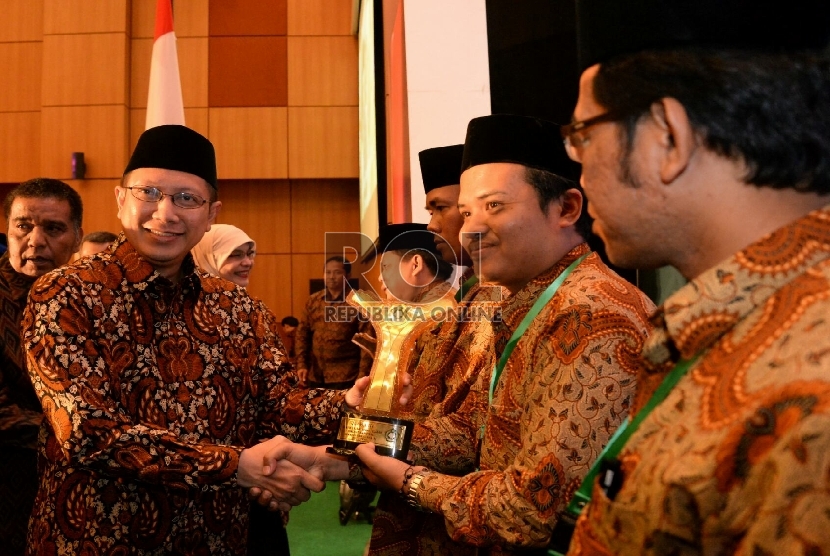 Menag Lukman Hakim Saifuddin memberikan penghargaan saat acara penganugrahan kantor urusan agama (KUA) dan keluarga sakinah teladan tingkat Nasional 2015 Di Jakarta, Selasa (18/8). 