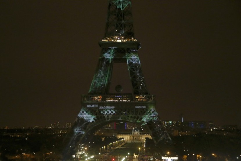 Menara Eiffel dihiasi lampu berwarna hijau.