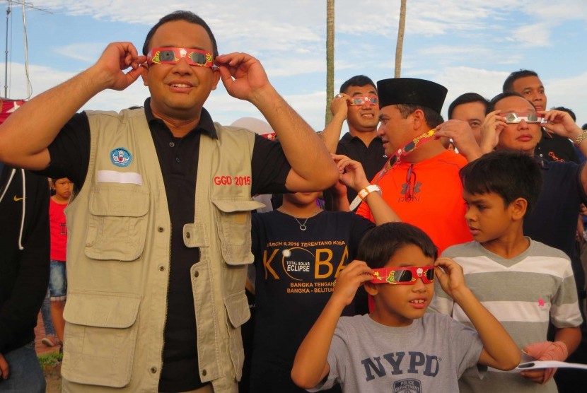 Mendikbud Anies Baswedan (kiri) menyaksikan gerhana matahari total (GMT) menggunakan kacamata khusus di pantai Terentang, Bangka Tengah, Bangka Belitung, Rabu (9/3)