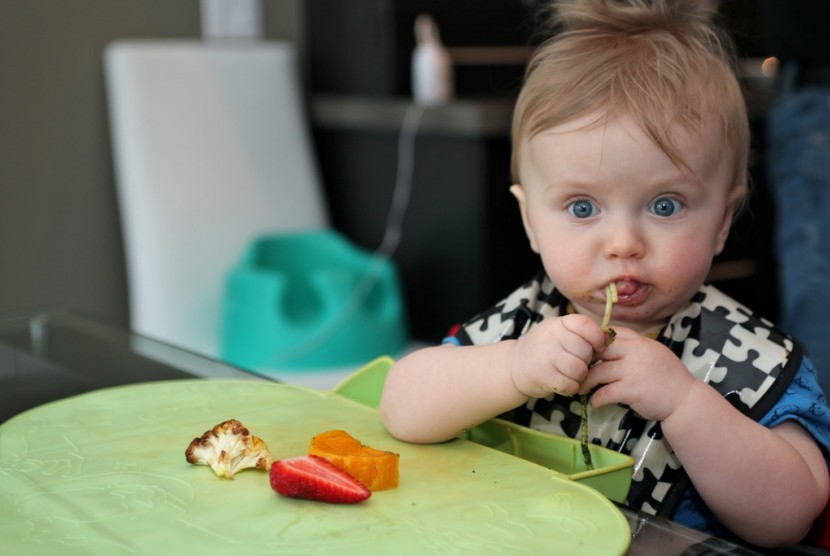 Mengajarkan bayi makan dengan metode Baby Led Weaning (BLW).