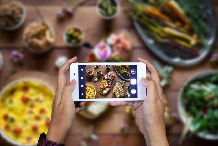 Mengambil foto makanan dengan menggunakan kamera ponsel (ilustrasi)
