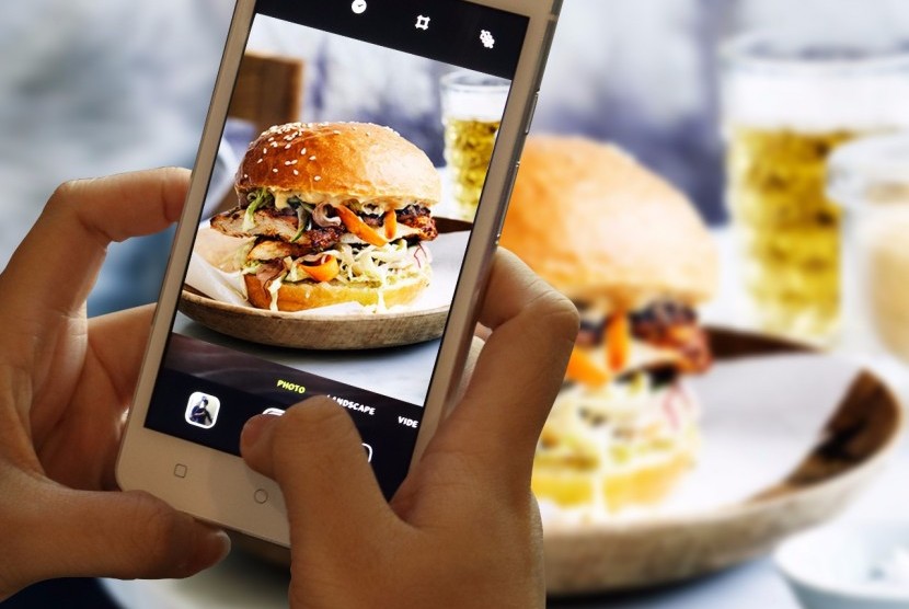 Mengambil foto makanan dengan ponsel (ilustrasi)