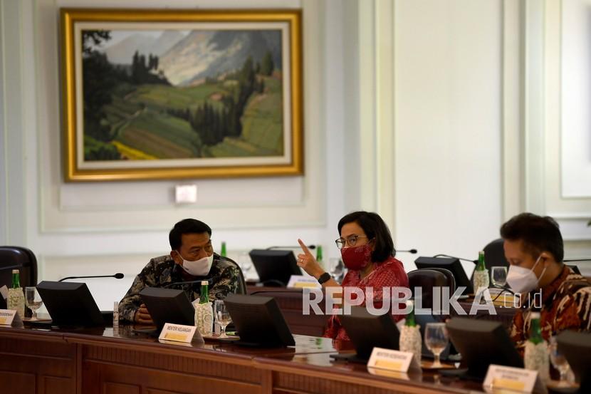Menkeu Sri Mulyani (tengah) berbincang dengan Kepala Staf Presiden Moeldoko (kiri) dan Menkes Budi Gunadi Sadikin saat menghadiri rapat terbatas terkait evaluasi pemberlakuan pembatasan kegiatan masyarakat (PPKM) di Kantor Presiden, Jakarta, Senin (3/1/2022).