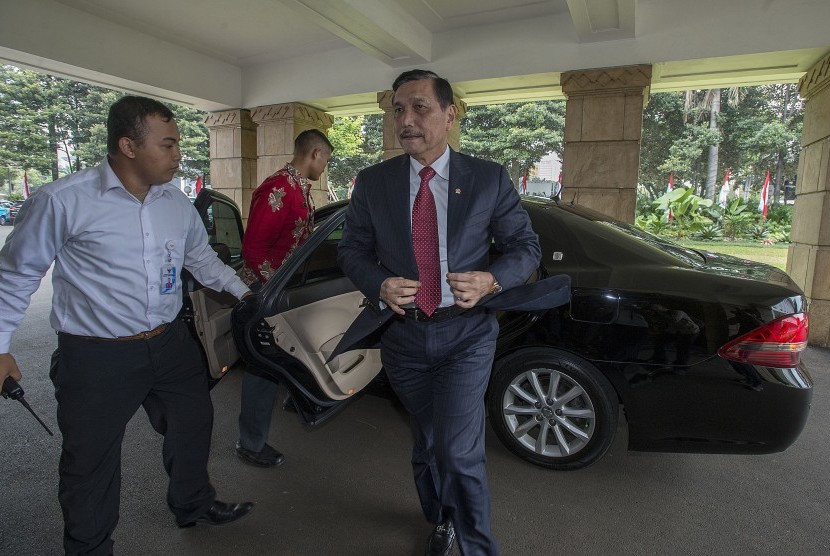 Menko Maritim dan Sumber Daya selaku Plt Menteri ESDM Luhut Binsar Pandjaitan (kanan) turun dari kendaraan dinasnya saat tiba di Kementerian ESDM, Jakarta, Selasa (16/8).