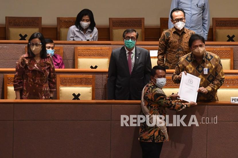 Menko Perekonomian Airlangga Hartarto (kanan) didampingi Menkumham Yasonna Laoly (kedua kiri) dan Menteri Keuangan Sri Mulyani (kiri) menerima laporan akhir dari Ketua Badan Legislasi DPR Supratman Andi (bawah) saat pembahasan tingkat II RUU Cipta Kerja pada Rapat Paripurna DPR di Kompleks Parlemen, Jakarta, Senin (5/10). Draf final UU Ciptaker hari ini diserahkan ke Presiden Joko Widodo untuk ditandatangani. (ilustrasi)