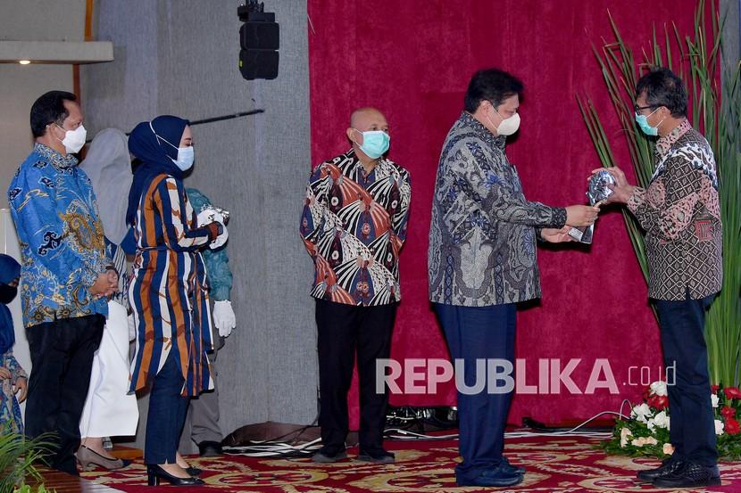 Menko Perekonomian Airlangga Hartarto (kedua kanan) memberikan penghargaan kepada Gubernur Sumatera Barat Irwan Prayitno (kanan) disaksikan Mendagri Tito Karnavian (kiri) dan Menteri Koperasi dan UKM Teten Masduki (tengah) dalam Rapat Koordinasi Nasional Pengendalian Inflasi Tahun 2020 di Kemenko Perekonomian, Jakarta, Kamis (22/10/2020).