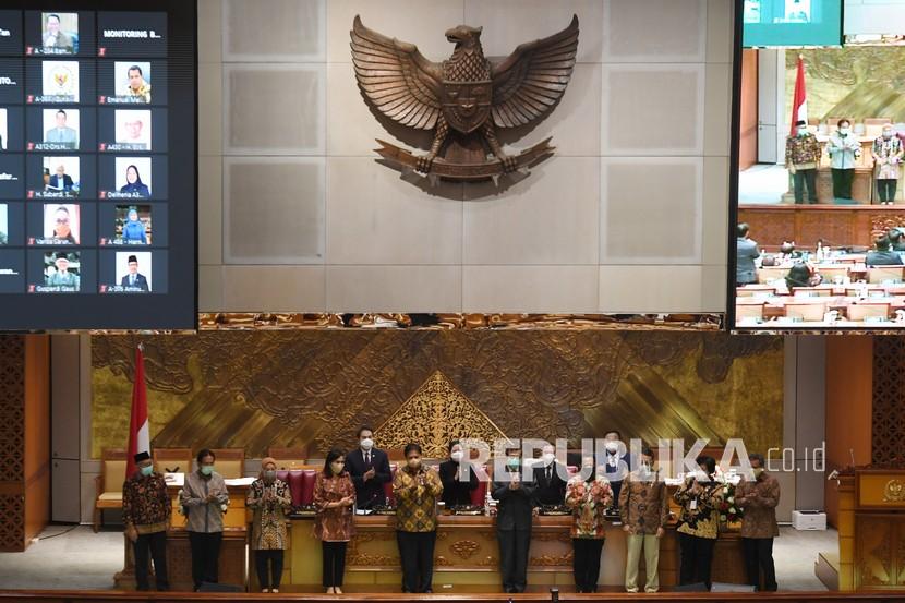 Menko Perekonomian Airlangga Hartarto (kelima kiri) bersama Menkumham Yasonna Laoly (kelima kanan), Menteri Keuangan Sri Mulyani (keempat kiri), Mendagri Tito Karnavian (keempat kanan), Menaker Ida Fauziyah (ketiga kiri), Menteri ESDM Arifin Tasrif (ketiga kanan), Menteri ATR/Kepala BPN Sofyan Djalil (kedua kiri) dan Menteri LHK Siti Nurbaya (kedua kanan) berfoto bersama dengan pimpinan DPR usai pengesahan UU Cipta Kerja pada Rapat Paripurna di Kompleks Parlemen, Senayan, Jakarta, Senin (5/10/2020). Dalam rapat paripurna tersebut Rancangan Undang-Undang Cipta Kerja disahkan menjadi Undang-Undang. 