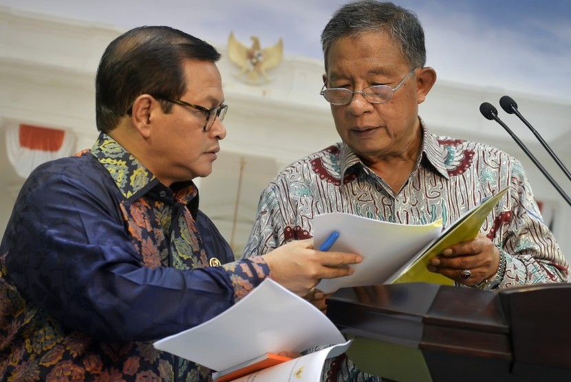 Menko Perekonomian Darmin Nasution (kanan) berdiskusi dengan Sekretaris Kabinet Pramono Anung (kiri) saat memaparkan Paket Kebijakan Ekonomi Tahap XI di Kantor Presiden, Jakarta, Selasa (29/3).