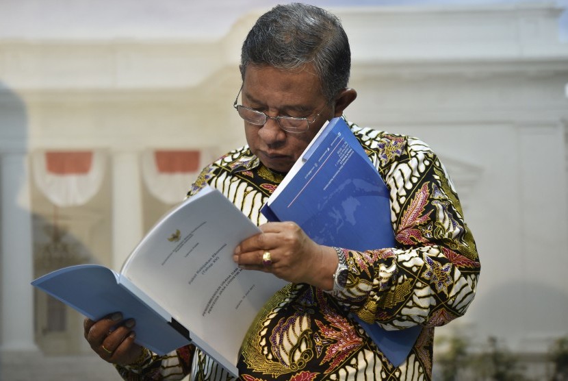 Menko Perekonomian Darmin Nasution membaca berkas Paket Kebijakan Ekonomi XV di Kantor Presiden, Jakarta, Kamis (15/6). 