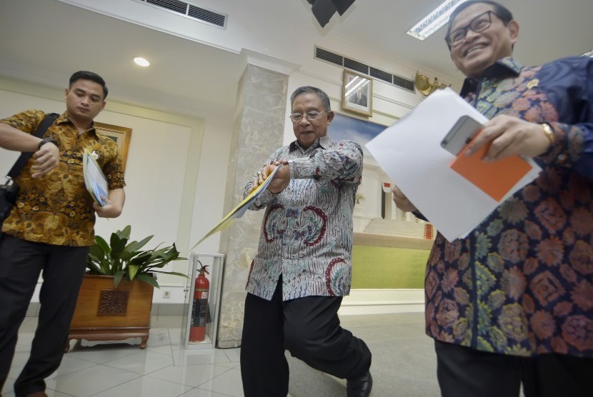Menko Perekonomian Darmin Nasution (tengah) bersama Sekretaris Kabinet Pramono Anung (kanan) meninggalkan tempat usai memaparkan Paket Kebijakan Ekonomi Tahap XI di Kantor Presiden, Jakarta, Selasa (29/3).