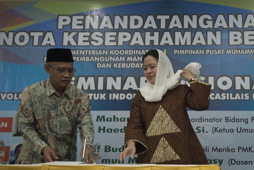 Menko PMK Puan Maharani (kanan) bersama Ketua Umum PP Muhammadiyah Haedar Nashir bersiap menandatangani nota kesepahaman bersama antara Kementerian PMK dengan PP Muhammadiyah di Kantor Pusat PP Muhammadiyah, Jumat (24/11). 