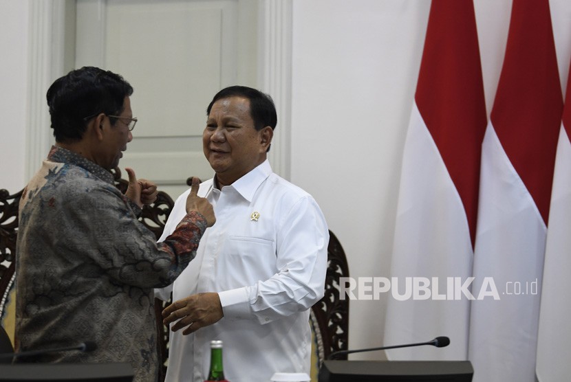 Menko Polhukam Mahfud MD (kiri) berbincang dengan Menteri Pertahanan Prabowo Subianto (kanan). (ilustrasi)