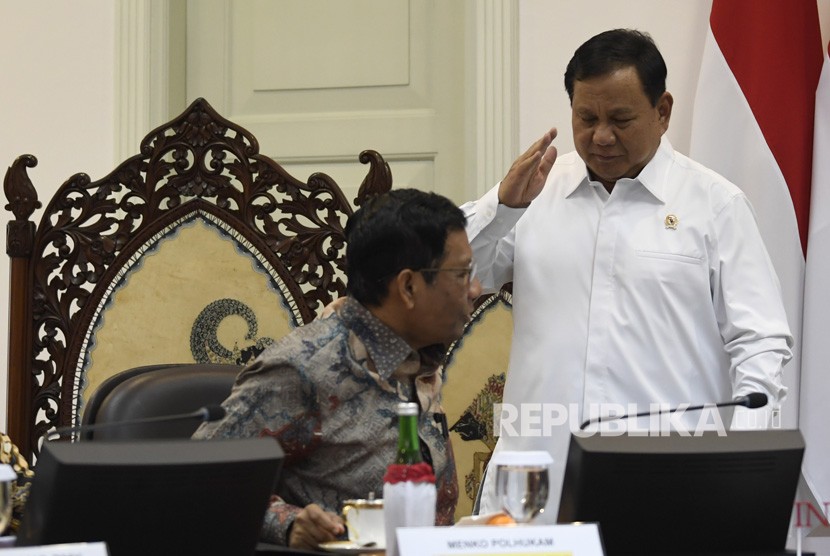 Menko Polhukam Mahfud MD (kiri) berbincang dengan Menteri Pertahanan Prabowo Subianto (kanan) saat akan mengikuti rapat terbatas tentang program dan kegiatan bidang politik, hukum dan keamanan di Kantor Presiden, Jakarta, Kamis (31/10/2019).