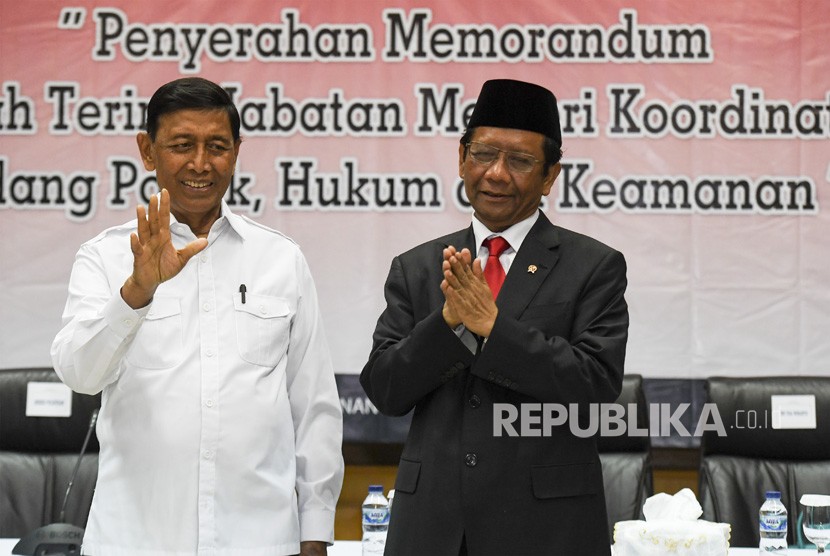 Menko Polhukam Mahfud MD (kiri) bersama mantan Menko Polhukam Wiranto (kanan) mengikuti serah terima jabatan di kantor Kemenko Polhukam, Jakarta, Rabu (23/10/2019).