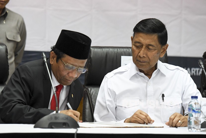 Menko Polhukam Mahfud MD (kiri) bersama mantan Menko Polhukam Wiranto menandatangani berita acara serah terima jabatan di kantor Kemenko Polhukam, Jakarta, Rabu (23/10/2019). 