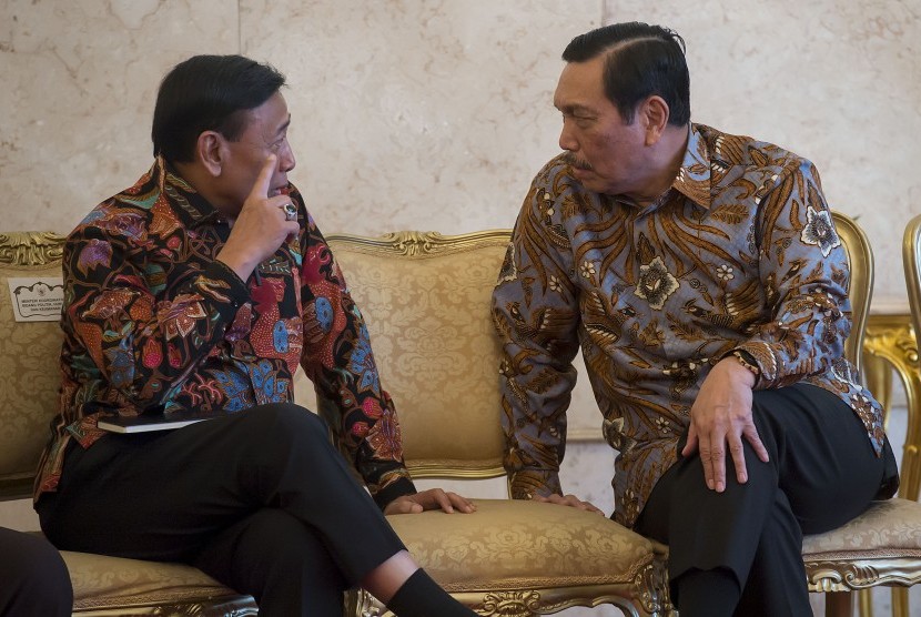 Menko Polhukam Wiranto (kiri) berbincang dengan Menko Maritim dan Sumber Daya Luhut Pandjaitan (kanan) sebelum mengikuti acara peluncuran Strategi Nasional Keuangan Inklusif di Istana Negara, Jakarta, Jumat (18/11). 