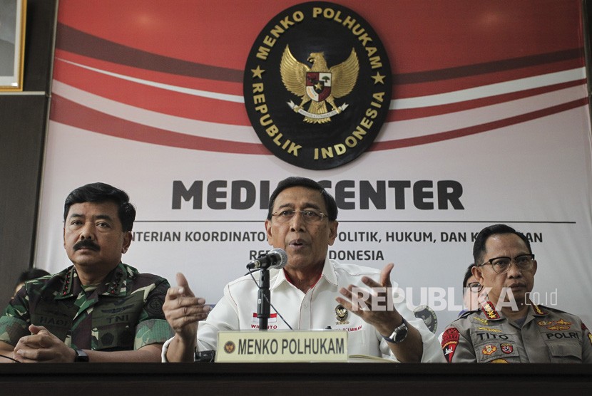 Menko Polhukam Wiranto (tengah) bersama Panglima TNI Marsekal TNI Hadi Tjahjanto (kiri) dan Kapolri Jenderal Pol Tito Karnavian (kanan) menyampaikan perkembangan pascakerusuhan di Jakarta dini hari tadi, di kantor Kemenko Polhukam, Jakarta, Rabu (22/5/2019).