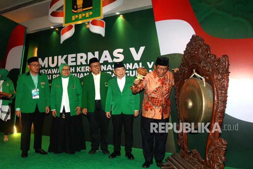 Menkopolhukam Mahfud MD (kanan) disaksikan Plt Ketum PPP Suharso Monoarfa (kedua kanan) dan Sekjen DPP PPP Arsul Sani (ketiga kanan) secara simbolis memukul gong sebagai tanda pembukaan Musyawarah Kerja Nasional ke-V PPP, di Jakarta, Sabtu (14/12/2019).