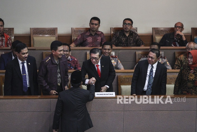 Menkumham Yasonna Laoly (tengah) berjabat tangan dengan Ketua Pansus RUU Anti-Terorisme Muhammad Syafii disaksikan Kepala BNPT Komjen Pol Suhardi Alius (kiri), Irwasum Polri Komjen Pol Putut Eko Bayuseno (kedua kiri), Jampidum Noor Rachmad (kedua kanan) dan Ketua Tim Panitia Kerja Pemerintah untuk RUU Anti-Terorisme Enny Nurbaningsih (kanan) pada Rapat Paripurna di Kompleks Parlemen Senayan, Jakarta, Jumat (25/5).