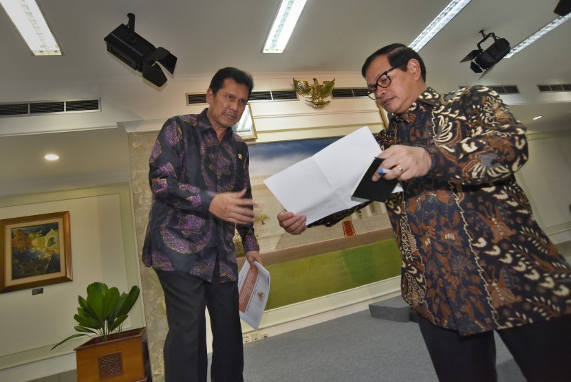 Menpan-RB Asman Abnur (kiri) berdiskusi dengan Sekretaris Kabinet Pramono Anung (kanan) saat akan memaparkan pembubaran sembilan lembaga nonstruktural (LNS) terkait penghematan anggaran dan efisiensi kinerja, di Jakarta, Selasa (20/9). 