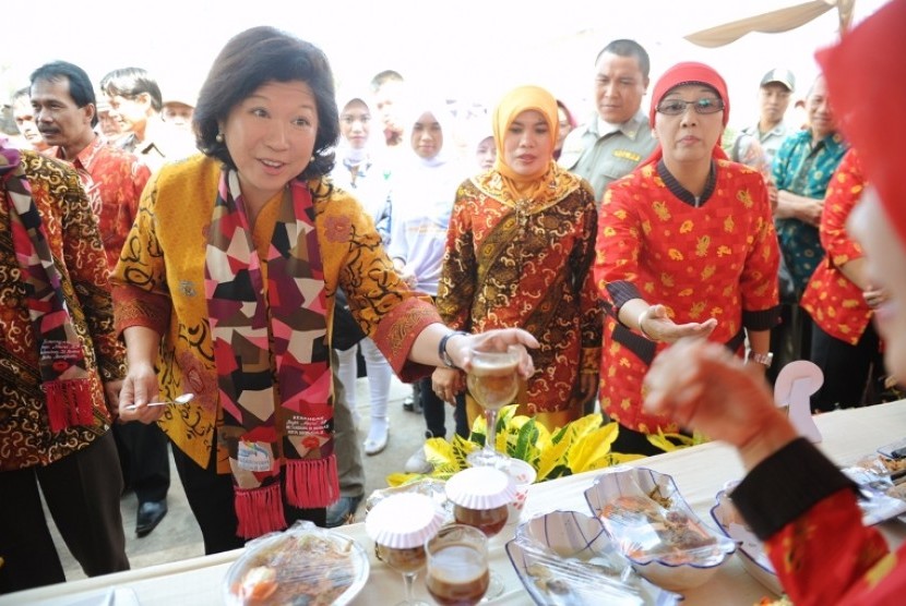 Menparekraf Mari Elka Pangestu (kiri) mencicipi makanan khas setempat saat menghadiri Festival Wisata Pesisir Pantai Panjang di Bengkulu, Minggu (27/5).
