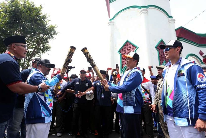 Menpora Imam Nahrawi (kedua kanan) didampingi Ketua Inapgoc Raja Sapta Oktohari (kanan) melakukan prosesi kirab obor (torch relay) Asian Para Games 2018 di Kedaton Kasultanan Ternate, Maluku Utara, Minggu (9/9).