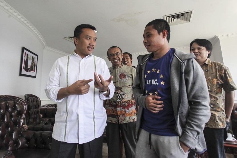 Menpora Imam Nahrawi (kiri) berbincang dengan pesepak bola Indonesia Evan Dimas (kanan) di gedung Kemenpora, Jakarta, Kamis (19/5). 