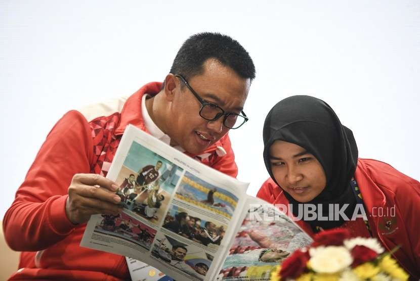 Menpora Imam Nahrawi (kiri) dan atlet Judo Indonesia Miftahul Jannah (kanan) berbincang-bincang saat konferensi pers di GBK Arena, Jakarta, Selasa (9/10).