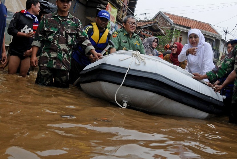 Mensos Khofifah Indar Parawansa (kanan) bersama Gubernur Provinsi Jawa Barat Ahmad Heryawan (keempat kiri) menaiki perahu saat meninjau sejumlah lokasi terdampak banjir di Desa Bojong Asih, Kabupaten Bandung, Jawa Barat, Senin (14/3).