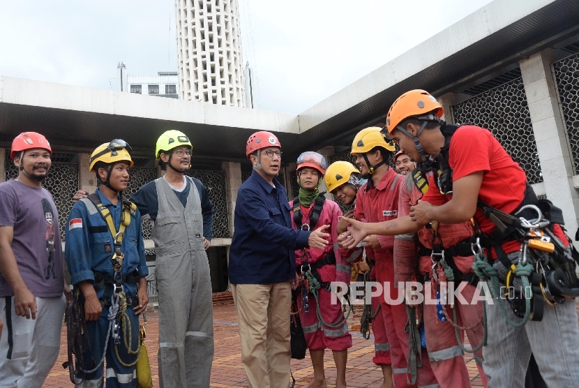 Menteri Agama Lukman Hakim Saifuddin berjabat tangan dengan para relawan saat meninjau proses membersihkan Masjid Istiqlal, Jakarta, Ahad (19/2). 
