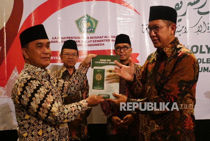  Menteri Agama Lukman Hakim Saifuddin (kanan) menyerahkan Manual Book Kemenag Qur’an Kemenag versi android kepada Imam Besar Masjid Agung Palembang Hanawi Dencik (kiri) sebagai tanda peluncuran aplikasi Quran Kemenag, di Jakarta, Selasa (30/8).