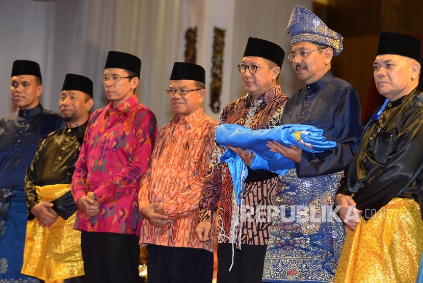 Menteri Agama Lukman Hakim Saifuddin (ketiga kanan) bersama bersama Gubernur Nusa Tenggara Barat TGH M. Zainul Majdi (ketiga kiri) dan PLT Gubernur Sumatera Utara Tengku Erry Nuradi (kedua kiri) berfoto bersama usai menerima bendera MTQ saat menghadiri pen