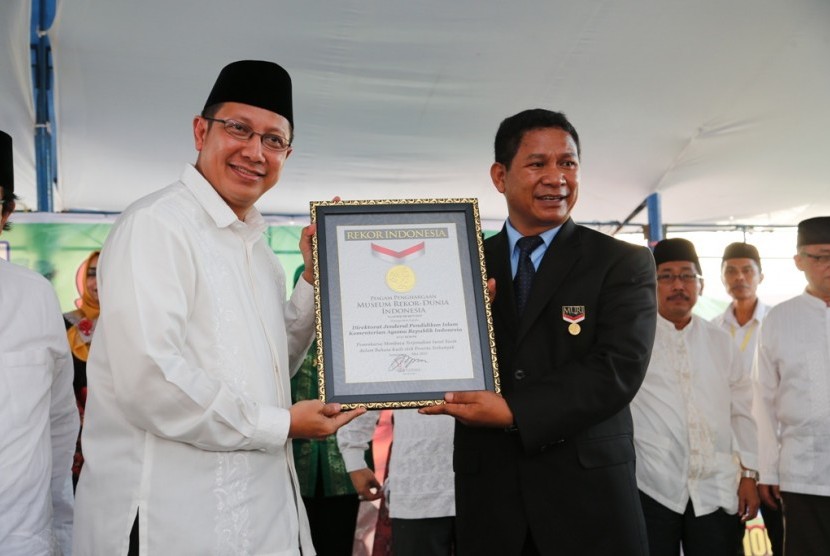 Menteri Agama, Lukman Hakim Saifuddin ketika menerima plakat Museum Rekor Indonesia untuk kategori Mengaji Massal di Palu. 