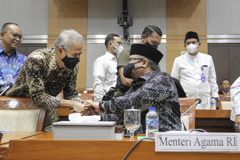 Menteri Agama Yaqut Cholil Qoumas (kanan) berjabat tangan dengan Kepala Badan Pelaksana Badan Pengelola Keuangan Haji (BPKH) Anggito Abimanyu (kiri) sebelum mengikuti rapat kerja dengan Komisi VIII DPR di Kompleks Parlemen, Senayan, Jakarta, Selasa (31/5/2022). Rapat tersebut membahas persiapan pelaksanaan Ibadah Haji dan alokasi kuota pengawas Haji tahun 1443H/2022. 