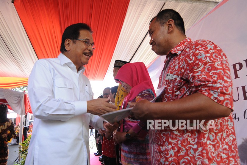 Menteri Agraria dan Tata Ruang/Badan Pertanahan Nasional (ATR/BPN) Sofyan Djalil (kiri) menyerahkan sertifikat tanah kepada masyarakat saat penyerahan sertifikat konsolidasi tanah untuk rakyat di Salatiga, Jawa Tengah, Jumat (6/12/2019).