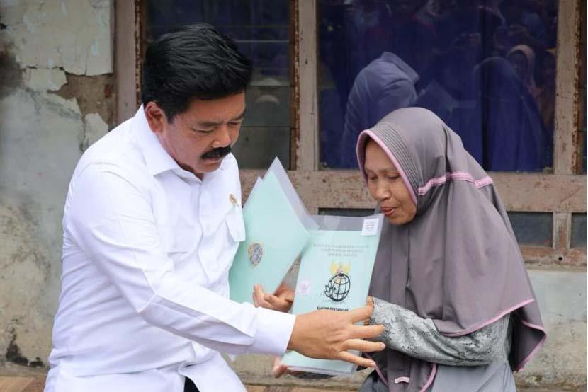 Menteri ATR/BPN Hadi Tjahjanto saat menyerahkan sertifikat tanah ke warga.