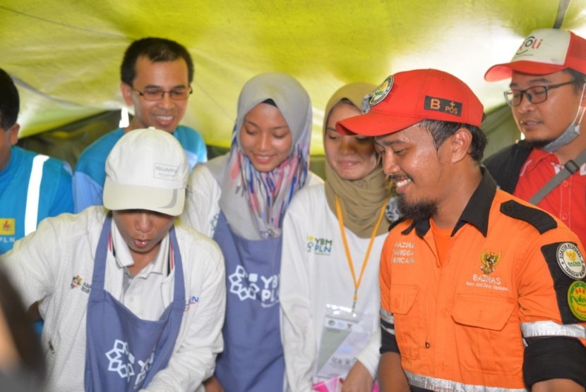 Menteri Badan Usaha Milik Negara (BUMN), Rini Soemarno turut memasak bersama relawan di dapur umum kerjasama Yayasan Baitul Mal Perusahaan Listrik Negara (YBM PLN) dan Baznas di Sumur, Pandeglang, Banten.