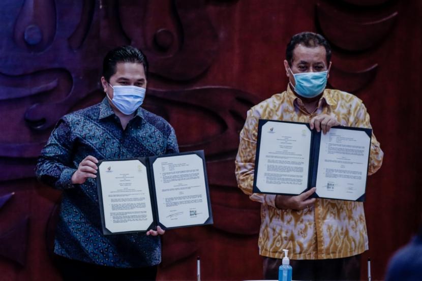 Menteri BUMN Erick Thohir dan Rektor Universitas Indonesia Ari Kuncoro menandatangani nota kesepahaman untuk mesinergikan tugas dan fungsi masing-masing lembaga dalam mendukung program pembangunan nasional di Balai Sidang, Universitas Indonesia, Selasa (23/6).