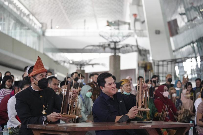 Menteri BUMN Erick Thohir (kanan) bersama Presiden Direktur PT Angkasa Pura II Muhammad Awaluddin (kiri) memainkan angklung pada pagelaran budaya Langgam Pancarona, Dahayu Nusantara di Bandara Internasional Soekarno-Hatta, Tangerang, Banten, Ahad (26/6/2022). Menteri BUMN mengatakan bandara internasional sebagai gerbang masuk ke Indonesia harus menjadi panggung tetap bagi para seniman dan budayawan lokal untuk mementaskan karya seni dan budaya nusantara. 