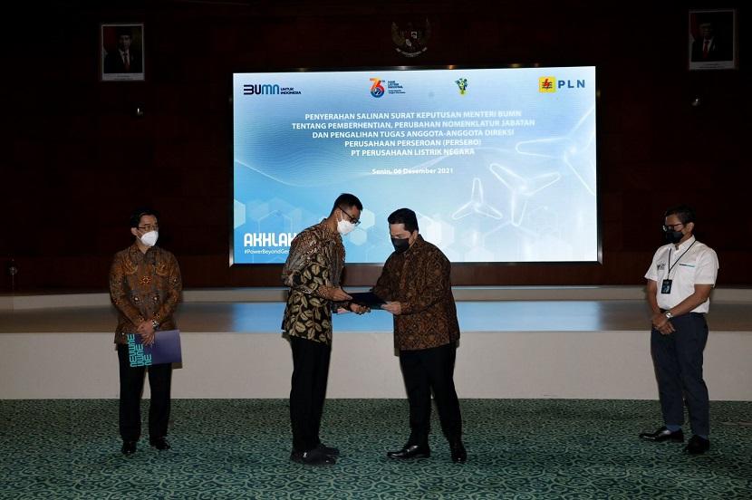 Menteri BUMN Erick Thohir (kanan) menyerahkan hasil keputusan Rapat Umum Pemegang Saham (RUPS) mengenai penunjukan Darmawan Prasodjo (kiri) sebagai Direktur Utama PT PLN (Persero) yang baru di kantor pusat PLN, Jakarta, Senin (6/12/2021).