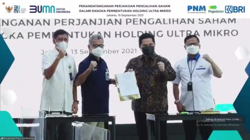 Menteri BUMN Erick Thohir (kedua dari kanan), Dirut Pegadaian Kuswiyoto (kiri), Dirut BRI Sunarso (kedua dari kiri), dan Dirut PNM Arief Mulyadi (kanan) saat penandatangan perjanjian pengalihan saham dalam rangka pembentukan Holding Ultramikro di Jakarta, Senin (13/9).